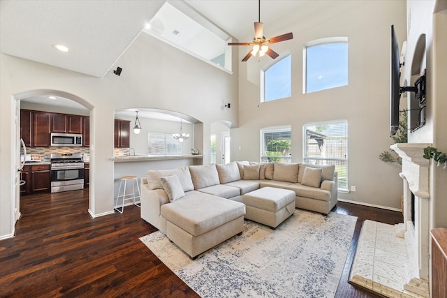 1402 Sullivan Springs Dr, Katy, TX 77494 - living area with arched walkways, dark wood finished floors, a ceiling fan, a towering ceiling, and a chandelier