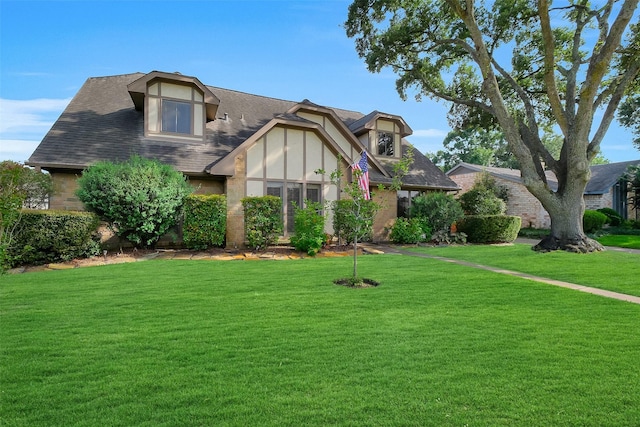 21307 Park Willow Dr, Katy, TX 77450 - tudor-style house with a front lawn, roof with shingles, and brick siding