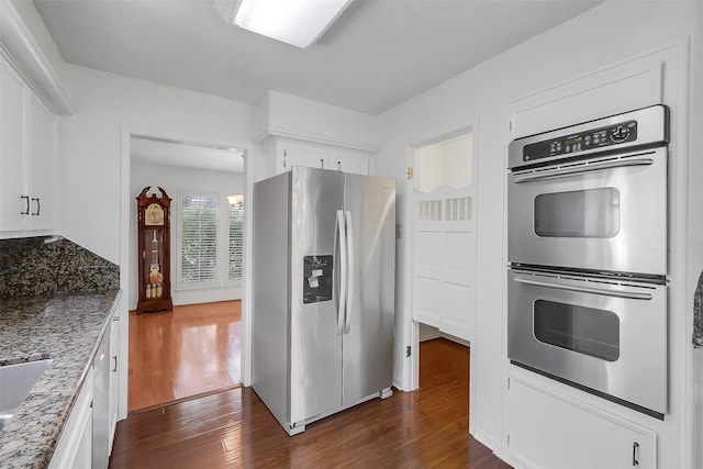 21307 Park Willow Dr, Katy, TX 77450 - kitchen featuring appliances with stainless steel finishes, dark wood finished floors, white cabinetry, and light stone countertops