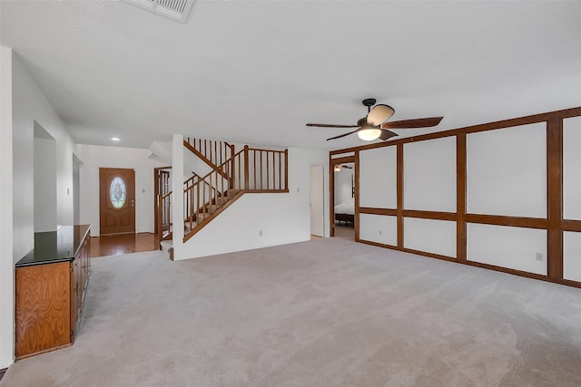 21307 Park Willow Dr, Katy, TX 77450 - unfurnished living room featuring ceiling fan, stairs, and light carpet