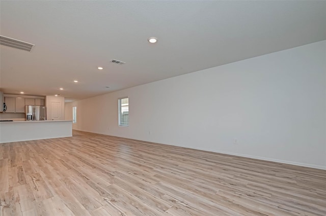 22156 Juniper Crossing Dr, New Caney, TX 77357 - unfurnished living room featuring light wood-style flooring and recessed lighting