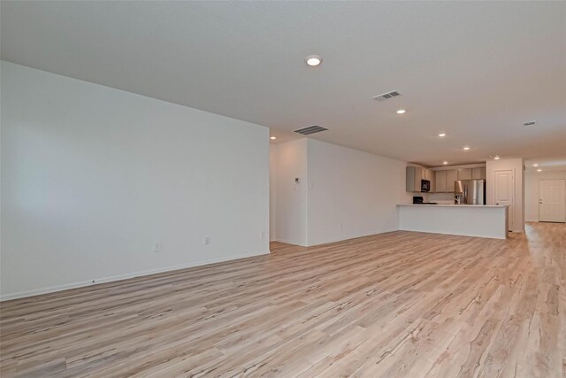 22156 Juniper Crossing Dr, New Caney, TX 77357 - unfurnished living room with recessed lighting and light wood-style floors