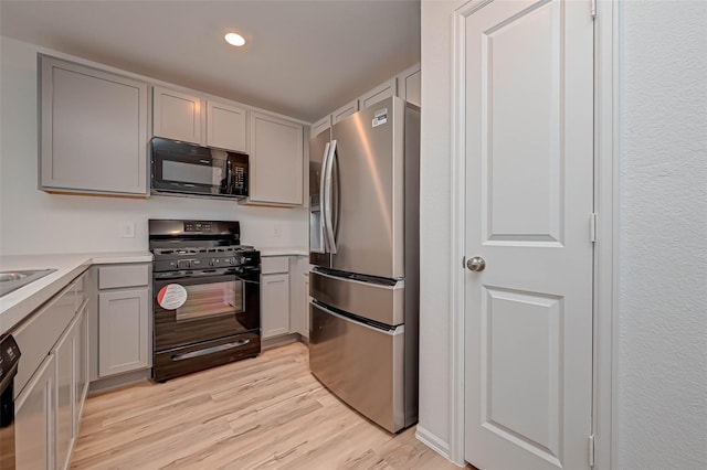 22156 Juniper Crossing Dr, New Caney, TX 77357 - kitchen with black appliances, gray cabinets, light wood-style flooring, light countertops, and recessed lighting
