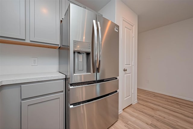 22156 Juniper Crossing Dr, New Caney, TX 77357 - kitchen featuring stainless steel fridge, gray cabinets, light countertops, and light wood-style floors
