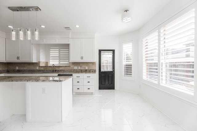 20411 Avery Point Dr, Katy, TX 77449 - kitchen featuring light marble finish floors, dark stone counters, white cabinets, recessed lighting, and tasteful backsplash