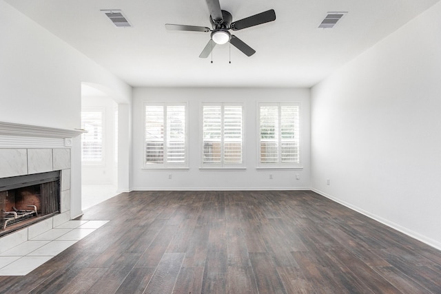 20411 Avery Point Dr, Katy, TX 77449 - unfurnished living room featuring wood finished floors, ceiling fan, a fireplace, and arched walkways
