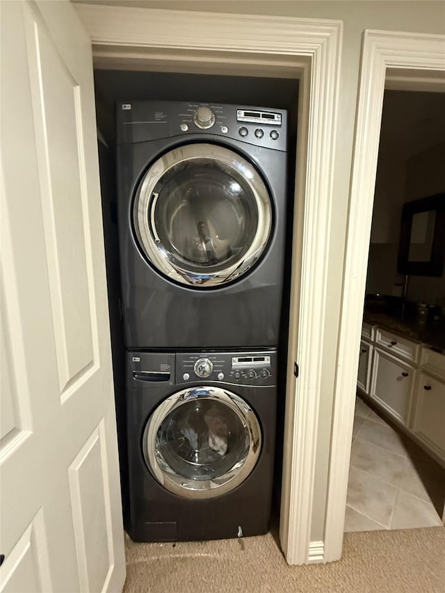 2330 Lakewood Yacht Club Dr Unit 7, Seabrook, TX 77586 - laundry area featuring stacked washing machine and dryer, light tile patterned flooring, and light carpet