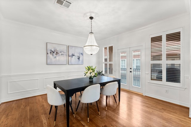 817 Rosine St, Houston, TX 77019 - dining room featuring french doors, crown molding, a chandelier, wood finished floors, and wainscoting