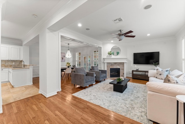 817 Rosine St, Houston, TX 77019 - living area featuring a ceiling fan, a fireplace, light wood-style floors, ornamental molding, and recessed lighting