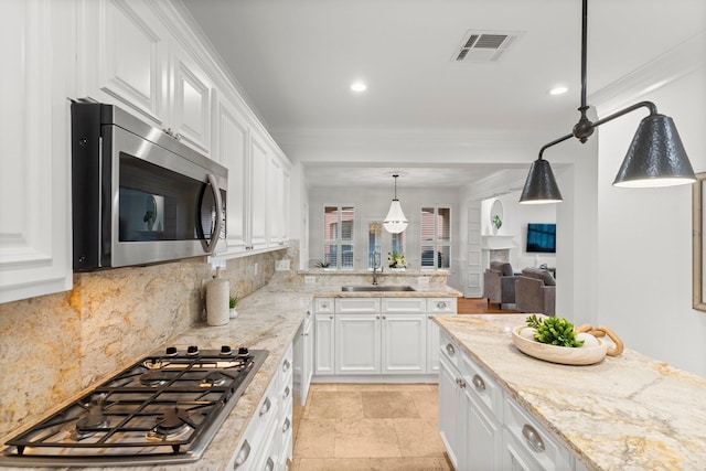 817 Rosine St, Houston, TX 77019 - kitchen with stainless steel appliances, backsplash, white cabinetry, crown molding, and recessed lighting