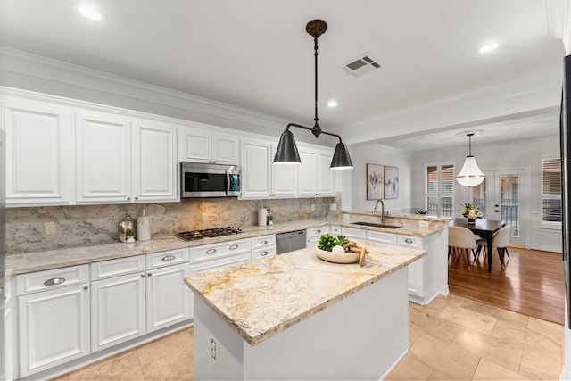 817 Rosine St, Houston, TX 77019 - kitchen with stainless steel appliances, a peninsula, a center island, decorative backsplash, and white cabinetry