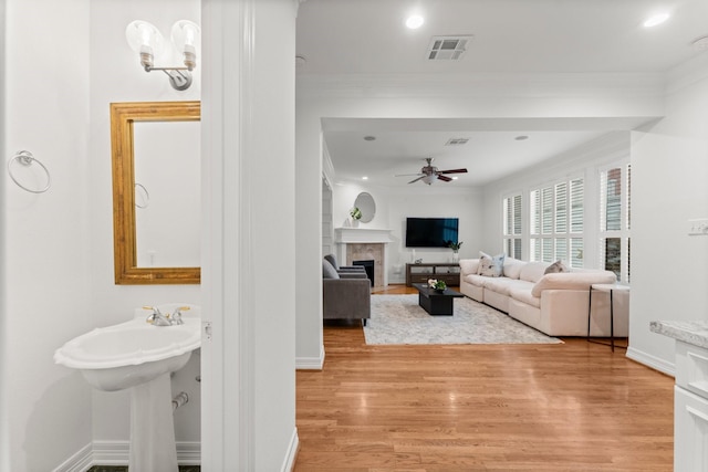 817 Rosine St, Houston, TX 77019 - living room with ceiling fan, crown molding, light wood-style flooring, a fireplace, and recessed lighting