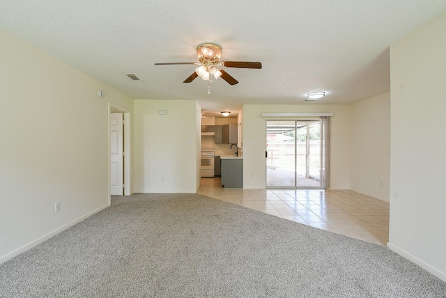 1117 Delores St, Kemah, TX 77565 - unfurnished living room with a ceiling fan, light colored carpet, and light tile patterned floors