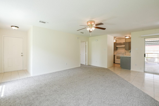 1117 Delores St, Kemah, TX 77565 - unfurnished living room featuring light tile patterned floors, a ceiling fan, and light carpet
