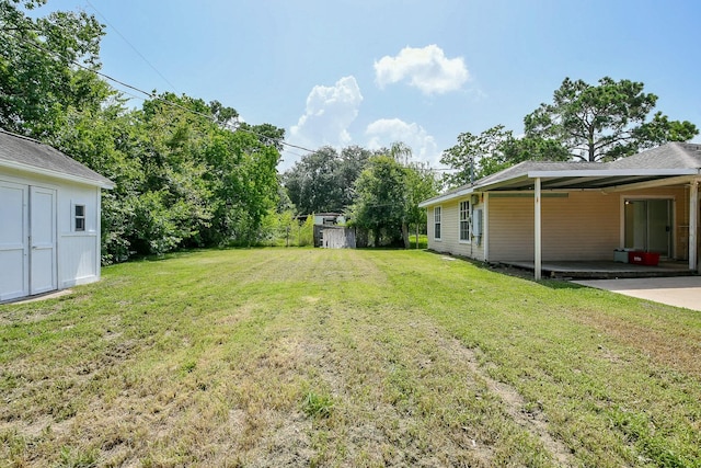 1117 Delores St, Kemah, TX 77565 - view of grassy yard featuring a carport, a storage shed, and driveway
