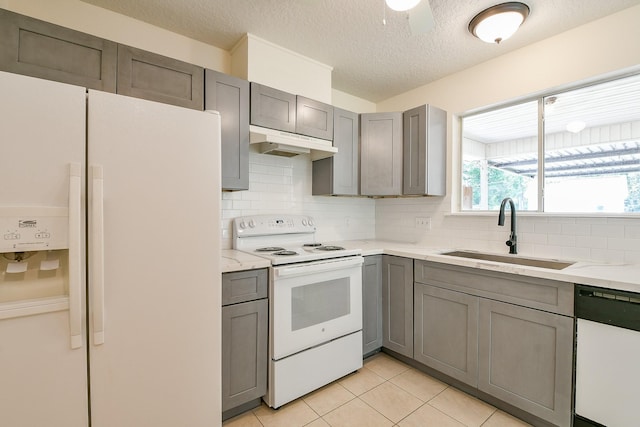 1117 Delores St, Kemah, TX 77565 - kitchen featuring white appliances, under cabinet range hood, gray cabinets, tasteful backsplash, and a textured ceiling
