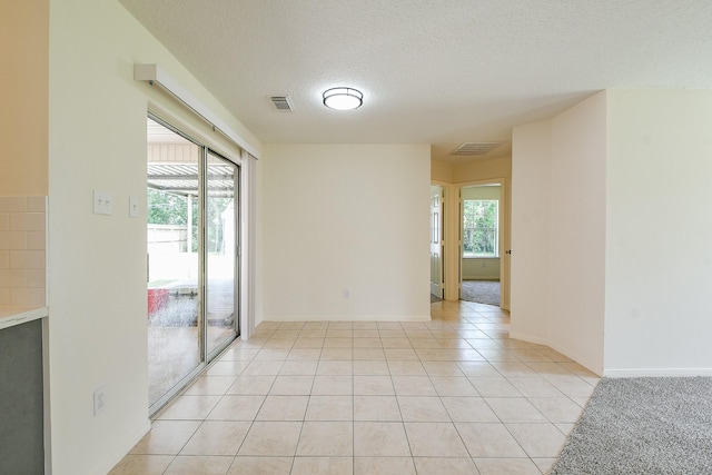 1117 Delores St, Kemah, TX 77565 - empty room with plenty of natural light, a textured ceiling, and light tile patterned floors