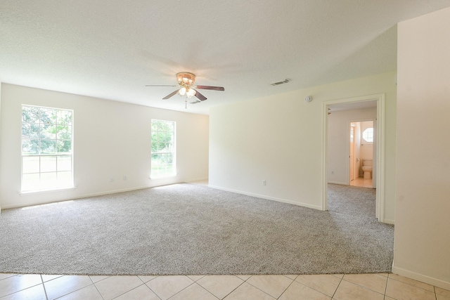 1117 Delores St, Kemah, TX 77565 - empty room with light carpet, a ceiling fan, and light tile patterned floors