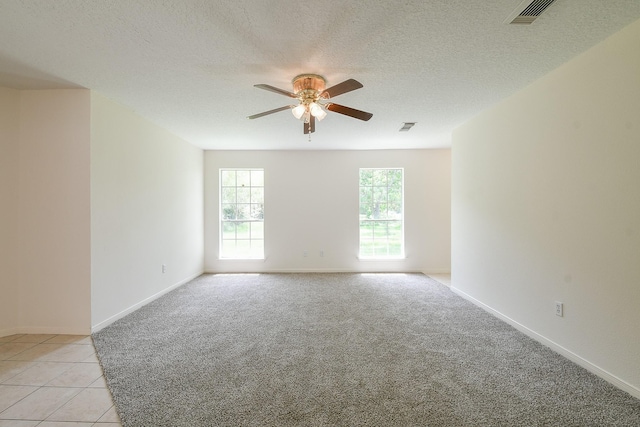 1117 Delores St, Kemah, TX 77565 - unfurnished room with a ceiling fan, light colored carpet, light tile patterned floors, and a textured ceiling