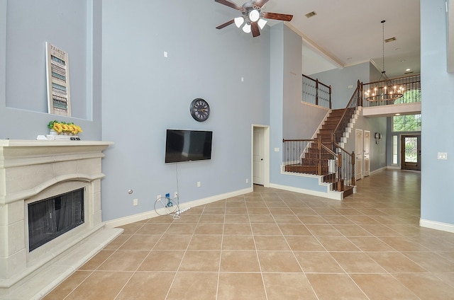 28722 Maple Red Dr, Katy, TX 77494 - unfurnished living room featuring a high ceiling, tile patterned floors, stairway, ceiling fan, and a fireplace with raised hearth