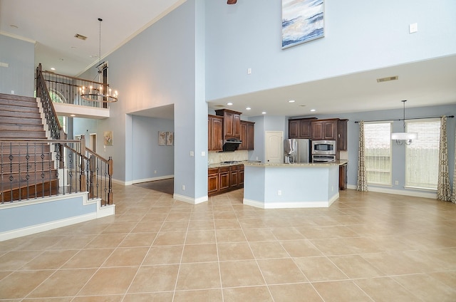 28722 Maple Red Dr, Katy, TX 77494 - unfurnished living room featuring a chandelier, light tile patterned floors, a high ceiling, stairway, and crown molding