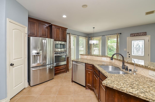 28722 Maple Red Dr, Katy, TX 77494 - kitchen with stainless steel appliances, light stone countertops, hanging light fixtures, light tile patterned floors, and recessed lighting