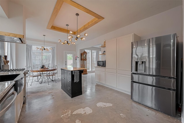 15610 Township Glen Ln, Cypress, TX 77433 - kitchen with stainless steel appliances, a chandelier, concrete floors, a tray ceiling, and white cabinetry
