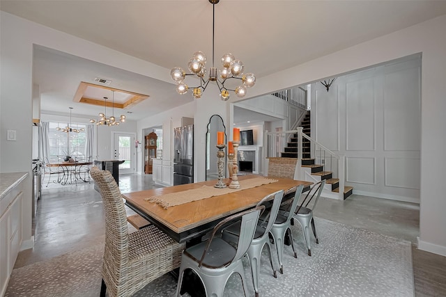 15610 Township Glen Ln, Cypress, TX 77433 - dining room featuring a chandelier, finished concrete floors, a tray ceiling, and stairway