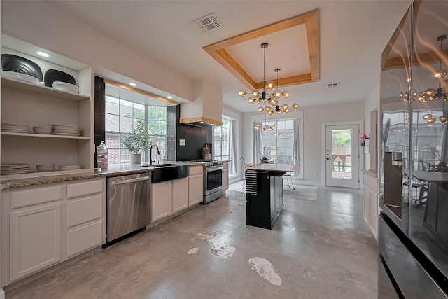 15610 Township Glen Ln, Cypress, TX 77433 - kitchen featuring stainless steel appliances, a chandelier, a raised ceiling, concrete flooring, and white cabinets