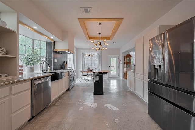 15610 Township Glen Ln, Cypress, TX 77433 - kitchen with stainless steel appliances, a chandelier, finished concrete floors, a raised ceiling, and open shelves