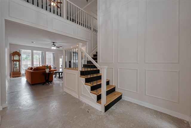 15610 Township Glen Ln, Cypress, TX 77433 - staircase featuring a decorative wall, ceiling fan, and concrete flooring