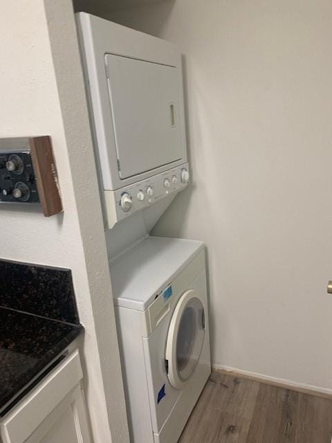 2425 Augusta Dr Unit 7, Houston, TX 77057 - washroom with stacked washer / drying machine and wood finished floors