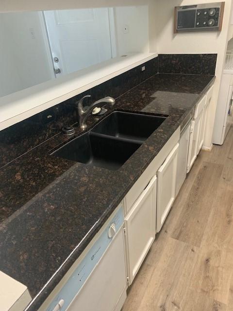 2425 Augusta Dr Unit 7, Houston, TX 77057 - kitchen featuring dishwasher, white cabinetry, light wood finished floors, and dark stone countertops