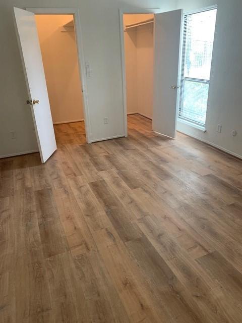 2425 Augusta Dr Unit 7, Houston, TX 77057 - unfurnished bedroom with a spacious closet, wood finished floors, and a closet