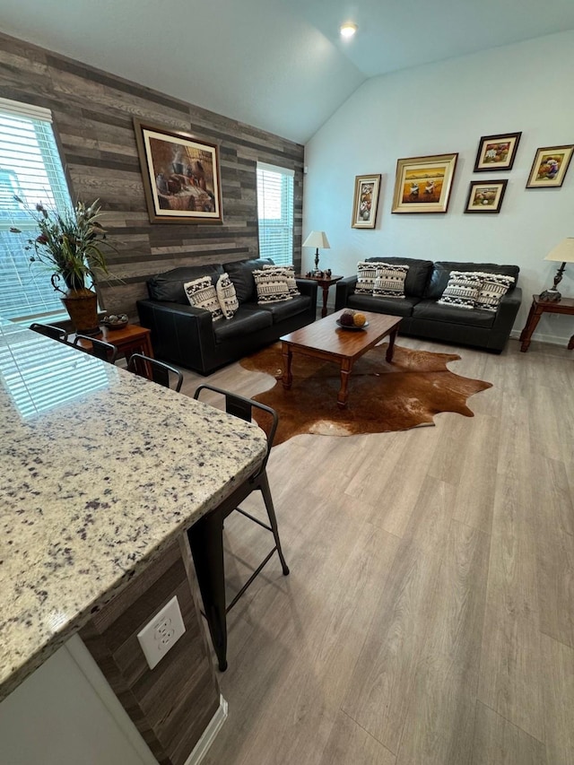 24223 Palomino Sage Trl, Katy, TX 77493 - living area with wood finished floors, lofted ceiling, wooden walls, and an accent wall