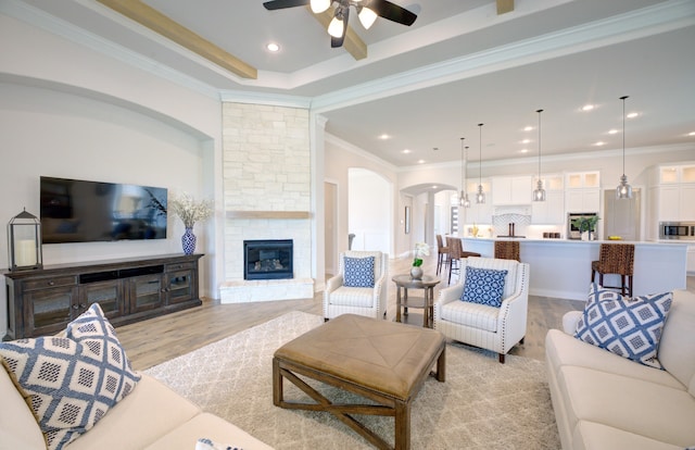 12607 Smokey Sunset Ct, Cypress, TX 77433 - living room with arched walkways, light wood-style floors, a ceiling fan, a fireplace, and recessed lighting