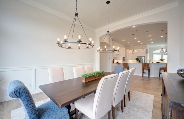 12607 Smokey Sunset Ct, Cypress, TX 77433 - dining room featuring a chandelier, ornamental molding, light wood-type flooring, wainscoting, and a decorative wall