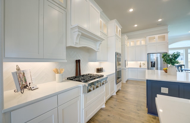 12607 Smokey Sunset Ct, Cypress, TX 77433 - kitchen featuring stainless steel appliances, crown molding, white cabinetry, tasteful backsplash, and glass insert cabinets