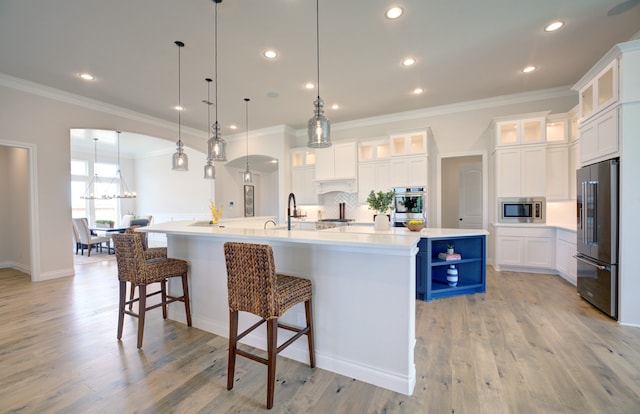 12607 Smokey Sunset Ct, Cypress, TX 77433 - kitchen featuring stainless steel appliances, a large island, ornamental molding, white cabinetry, and recessed lighting