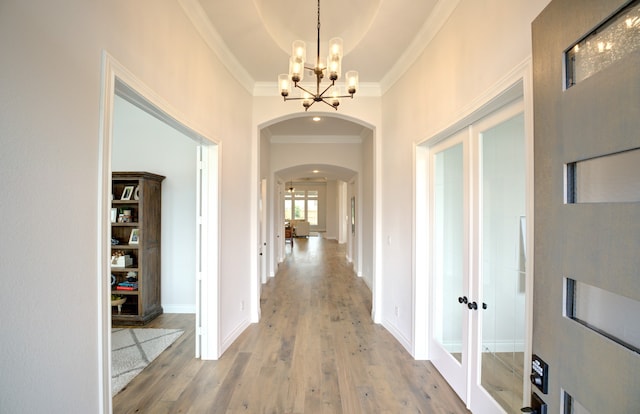 12607 Smokey Sunset Ct, Cypress, TX 77433 - hall featuring crown molding, arched walkways, a chandelier, light wood-type flooring, and french doors