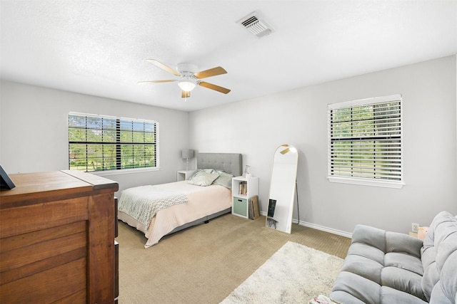 3135 Forest Hill E Rd, La Grange, TX 78945 - bedroom with multiple windows, light colored carpet, and ceiling fan