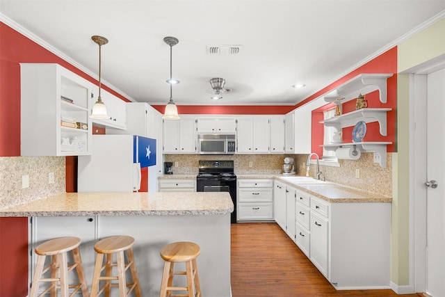 3135 Forest Hill E Rd, La Grange, TX 78945 - kitchen featuring stainless steel microwave, black / electric stove, open shelves, freestanding refrigerator, and a peninsula
