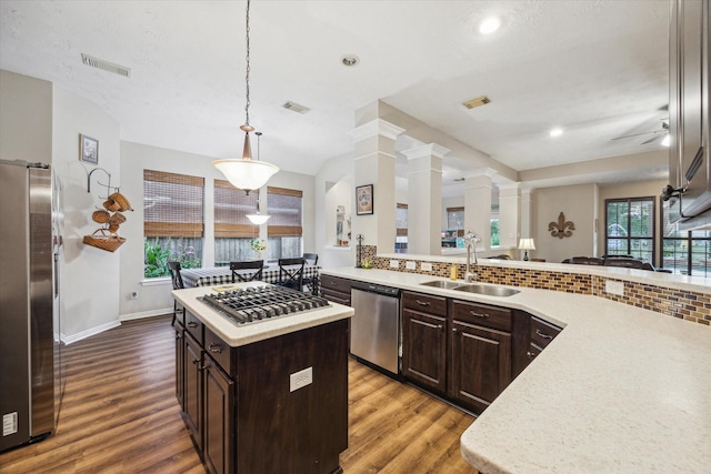 3732 Coral Reef Dr, Seabrook, TX 77586 - kitchen with stainless steel appliances, wood finished floors, light countertops, dark brown cabinetry, and recessed lighting