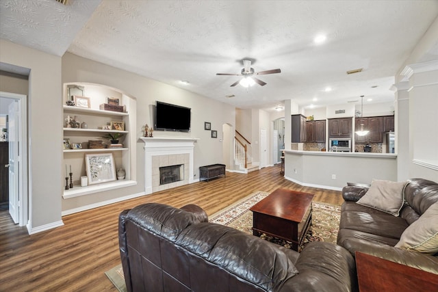 3732 Coral Reef Dr, Seabrook, TX 77586 - living area featuring a ceiling fan, wood finished floors, a fireplace, stairway, and built in features