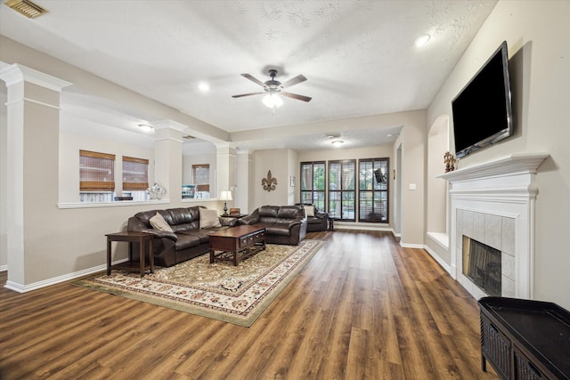 3732 Coral Reef Dr, Seabrook, TX 77586 - living room featuring decorative columns, wood finished floors, a ceiling fan, a tile fireplace, and recessed lighting