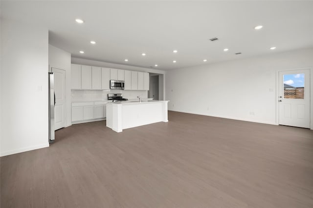 2435 Rooke Rd, Bryan, TX 77807 - kitchen with stainless steel appliances, recessed lighting, wood finished floors, open floor plan, and white cabinets