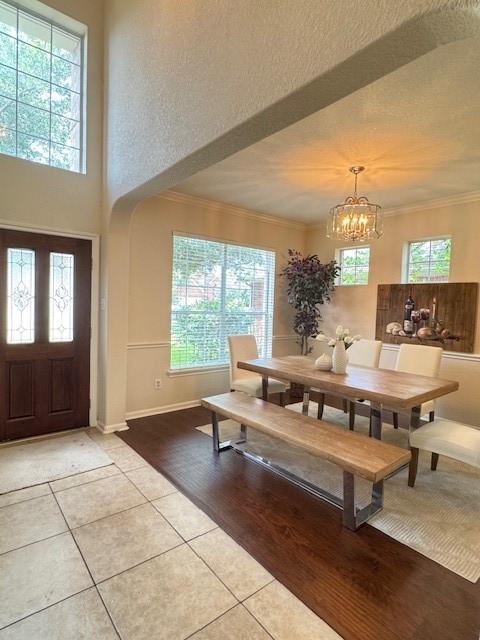 4126 Winesap Bend Dr, Stafford, TX 77477 - dining area with light tile patterned floors, a chandelier, and ornamental molding