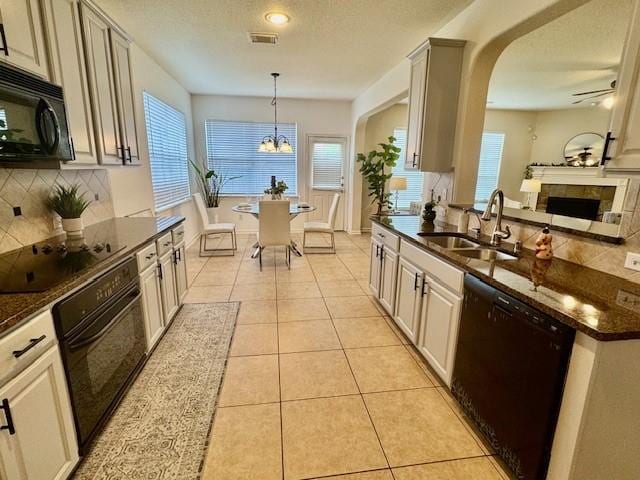 4126 Winesap Bend Dr, Stafford, TX 77477 - kitchen with black appliances, backsplash, arched walkways, a chandelier, and a textured ceiling