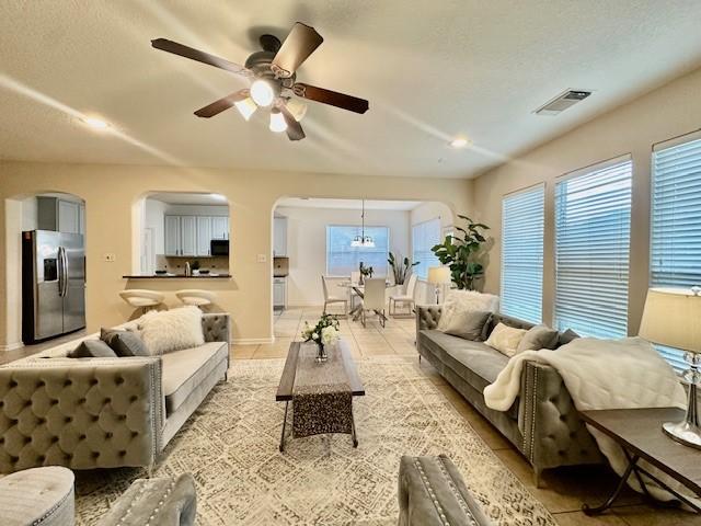 4126 Winesap Bend Dr, Stafford, TX 77477 - living room with ceiling fan, arched walkways, plenty of natural light, and light tile patterned flooring