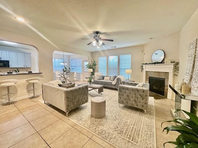4126 Winesap Bend Dr, Stafford, TX 77477 - living room featuring light tile patterned floors, ceiling fan, and a fireplace